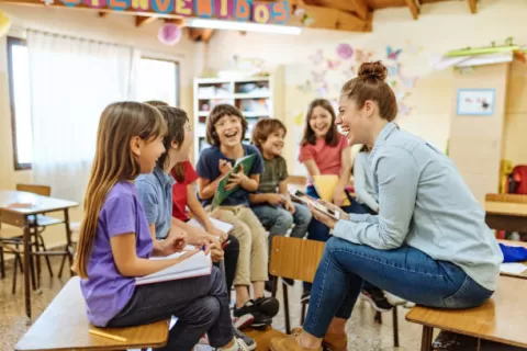 Adulte assis sur une table avec des enfants